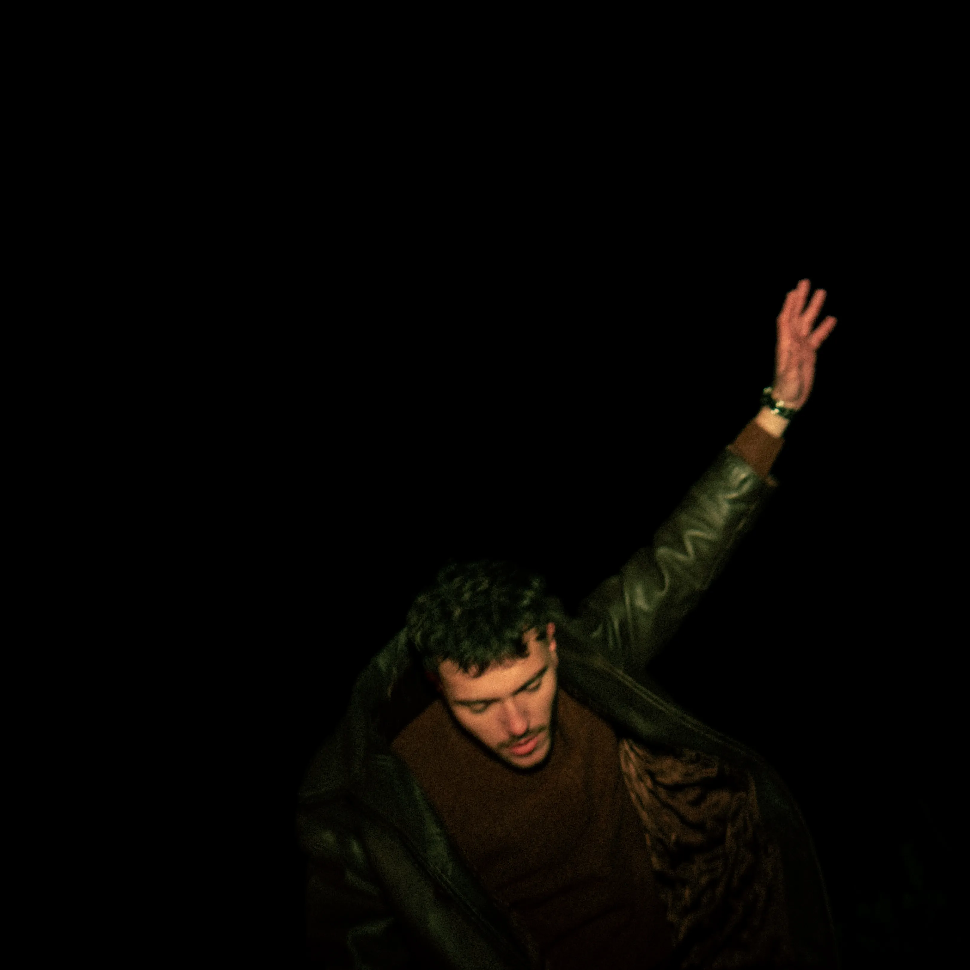 Homme levant le bras dans la nuit