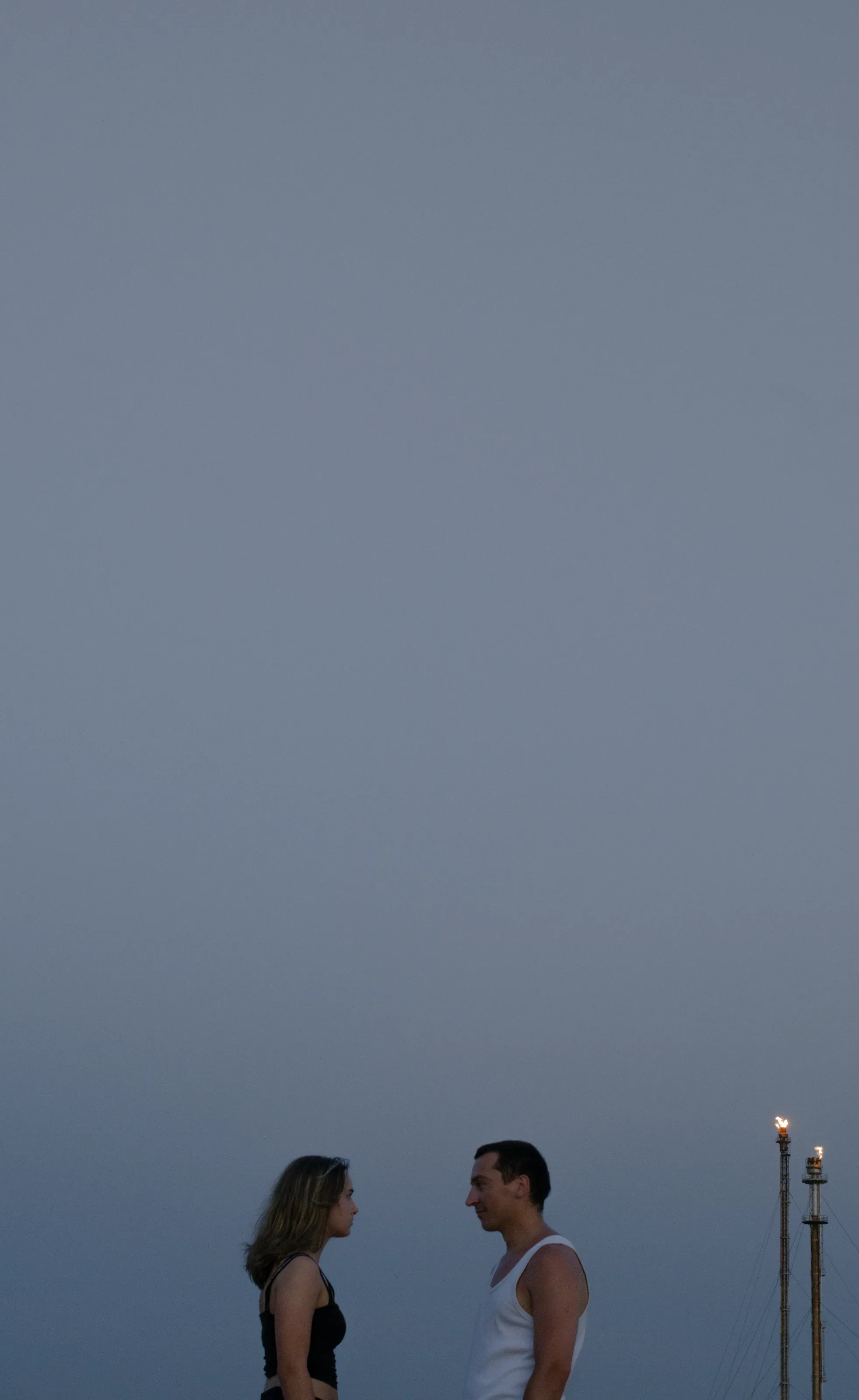 Deux personnes face à face sous un ciel gris
