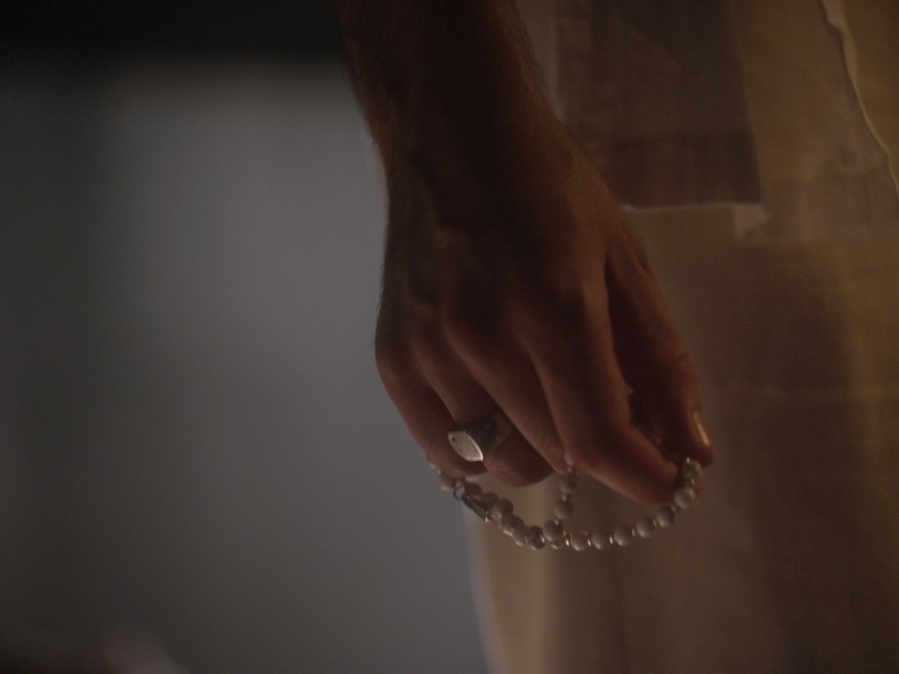 Main tenant un collier de perles