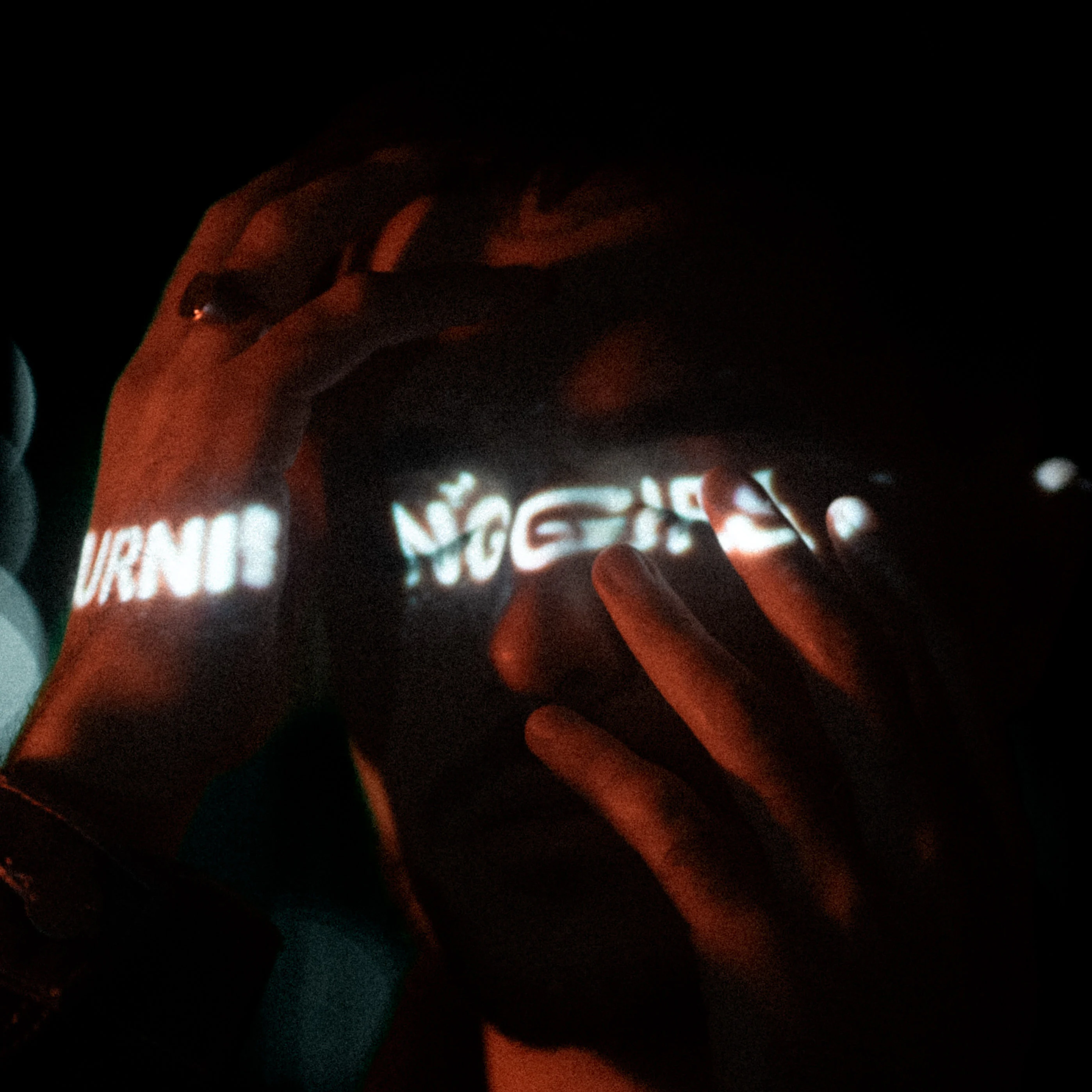 Mains éclairées par des lettres lumineuses