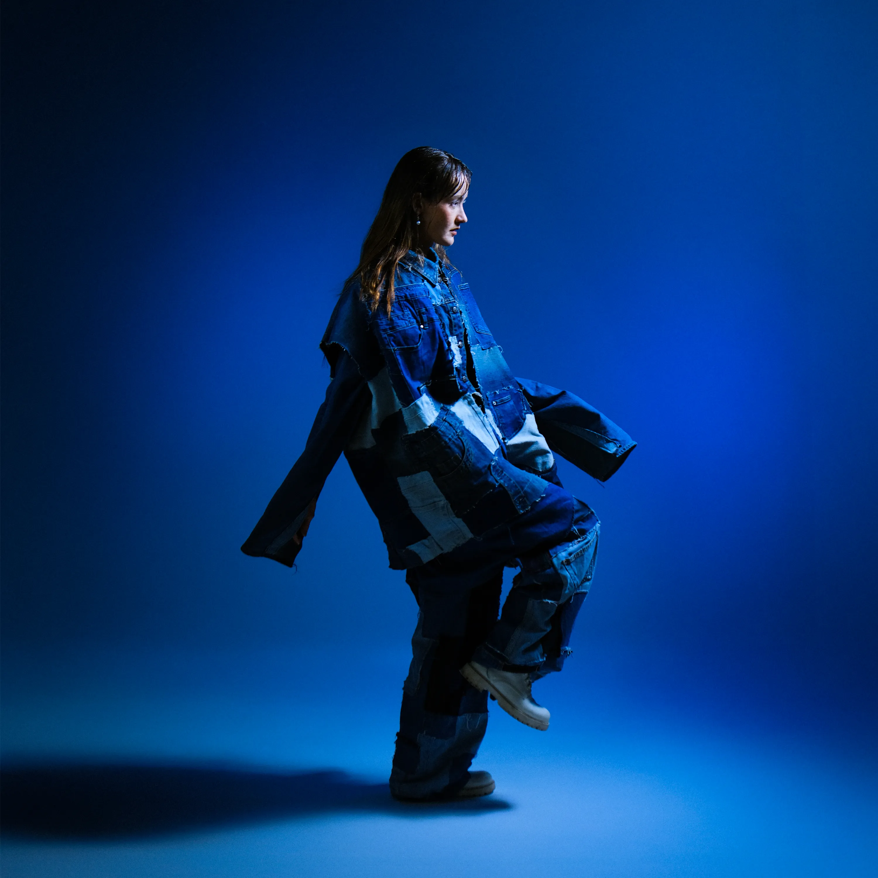 Femme en denim dansant sur fond bleu