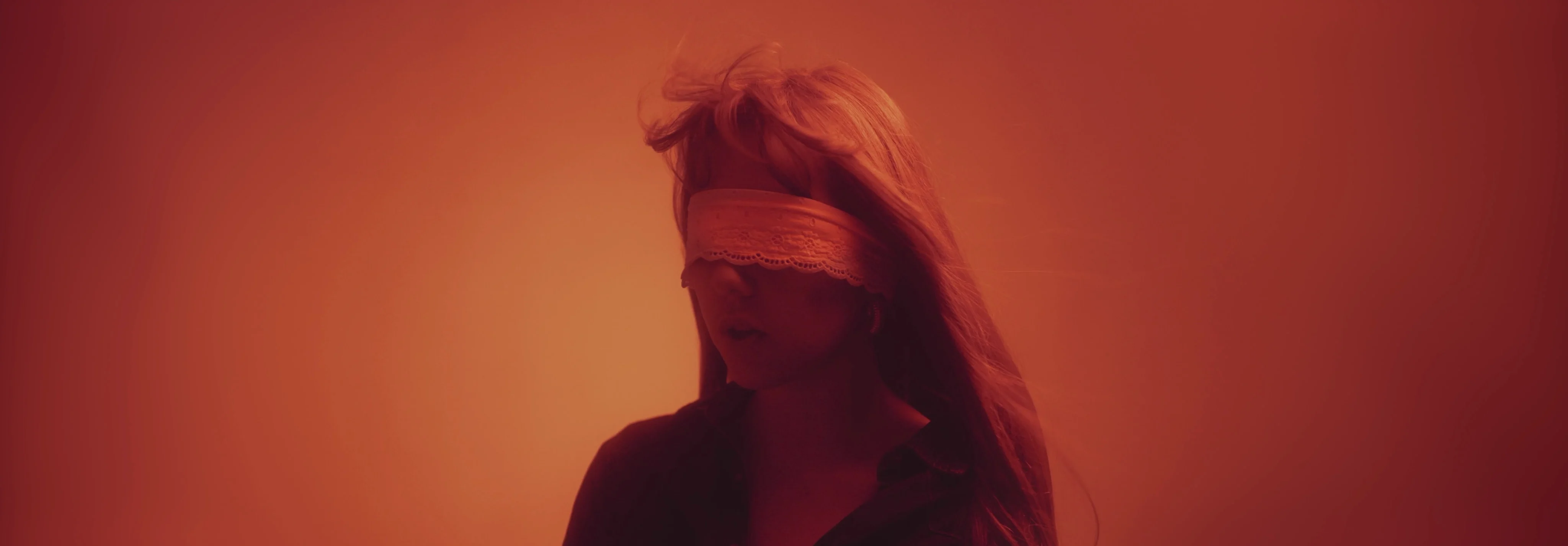Femme aux yeux bandés dans une lumière rouge